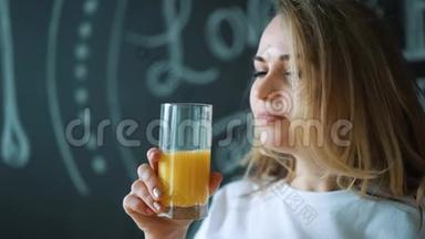 年轻的美女喝果汁，女孩早上早餐喝新鲜的橘子